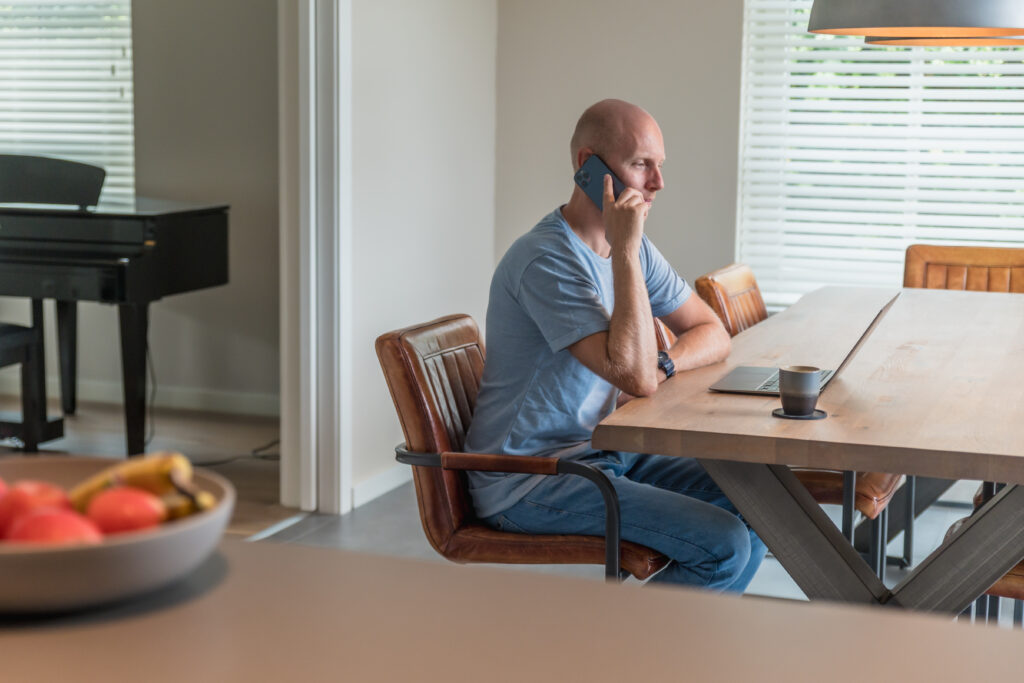 Branding shoot van ondernemer die zit te werken achter zijn keukentafel